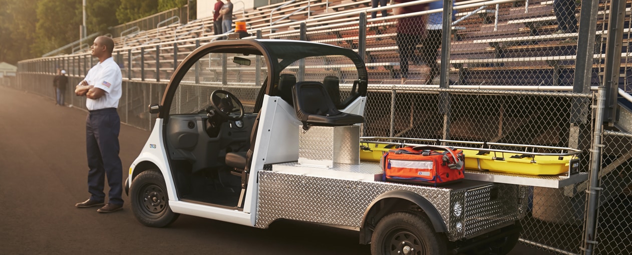 man standing next to electric vehicle loaded with first aid equipment